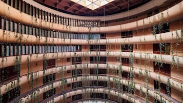 A multi-level atrium with curved balconies and hanging plants.