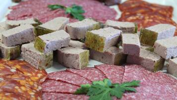 Una variedad de embutidos en rebanadas, incluyendo salami y paté, dispuestas en un plato.