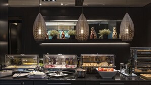 Un área de bufé con diferentes opciones de comida y una cocina moderna.