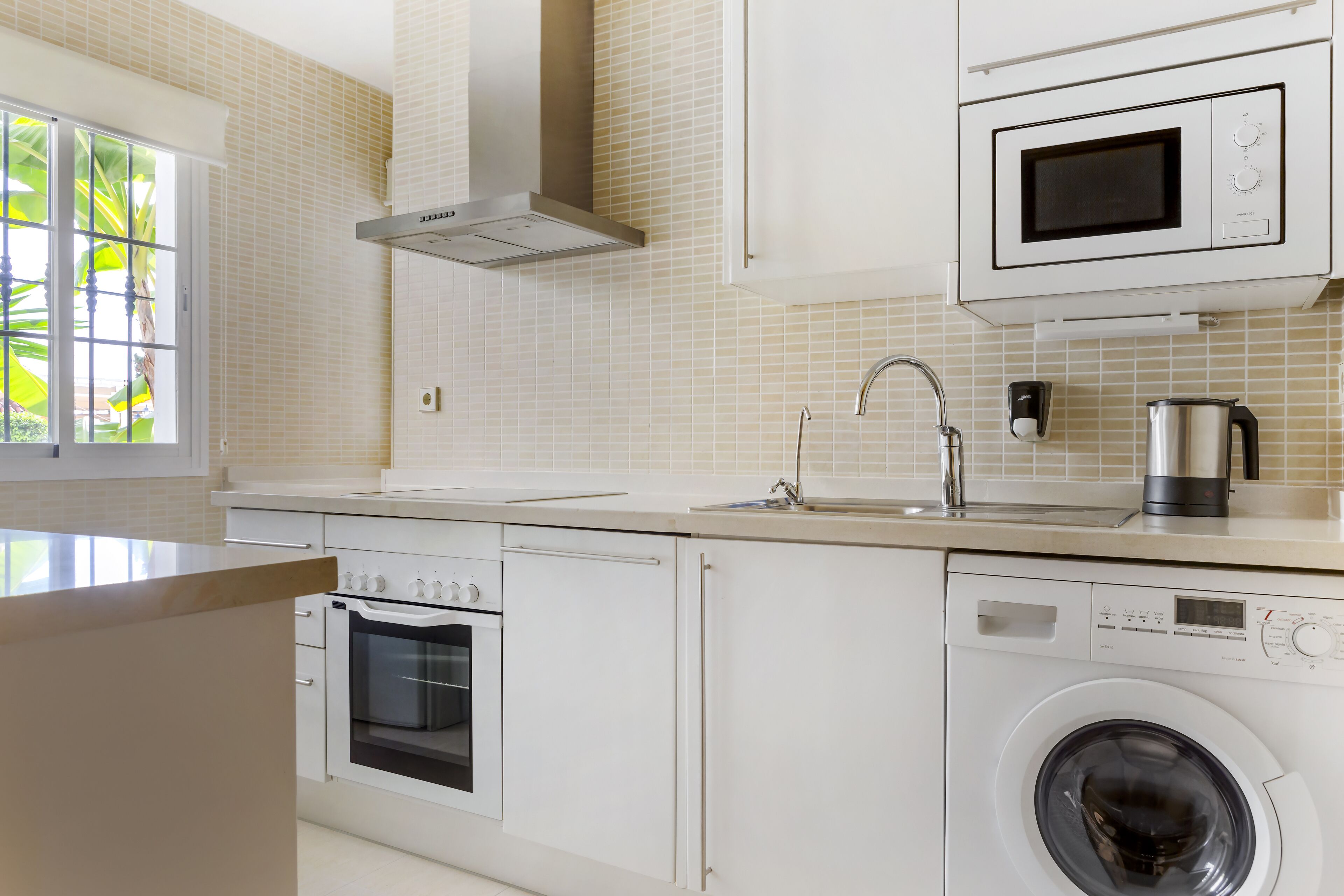 A modern kitchen with a built-in oven, microwave, and dishwasher.