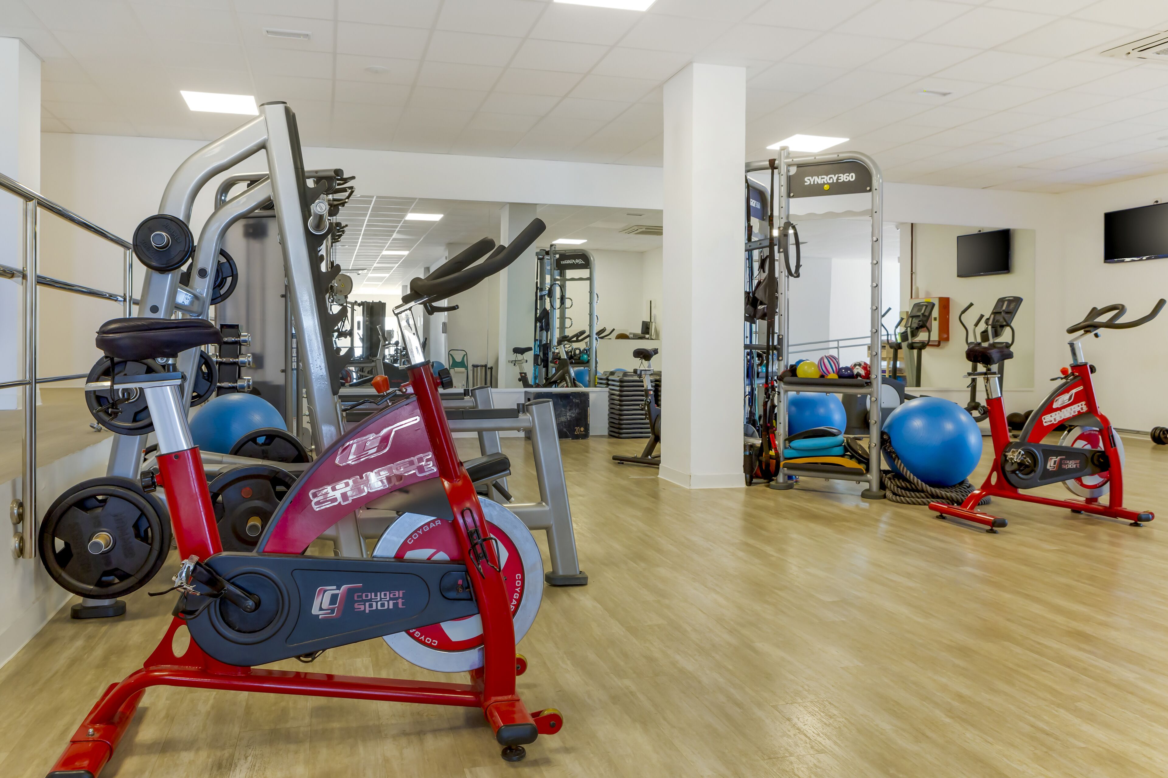 A gym with cardio equipment, weight machines, and exercise balls.