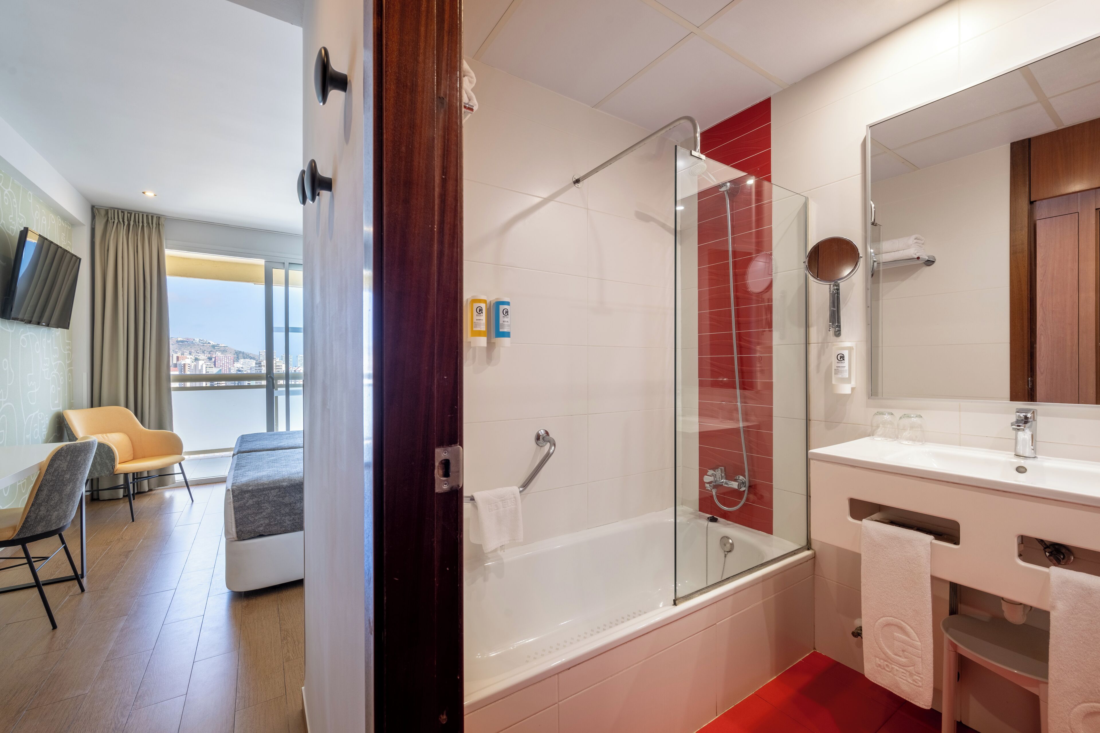 A modern bathroom with a glass-enclosed shower, a white sink, and a large mirror.