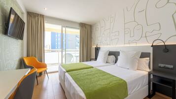 A hotel room with two beds, a TV, a desk, and a chair.