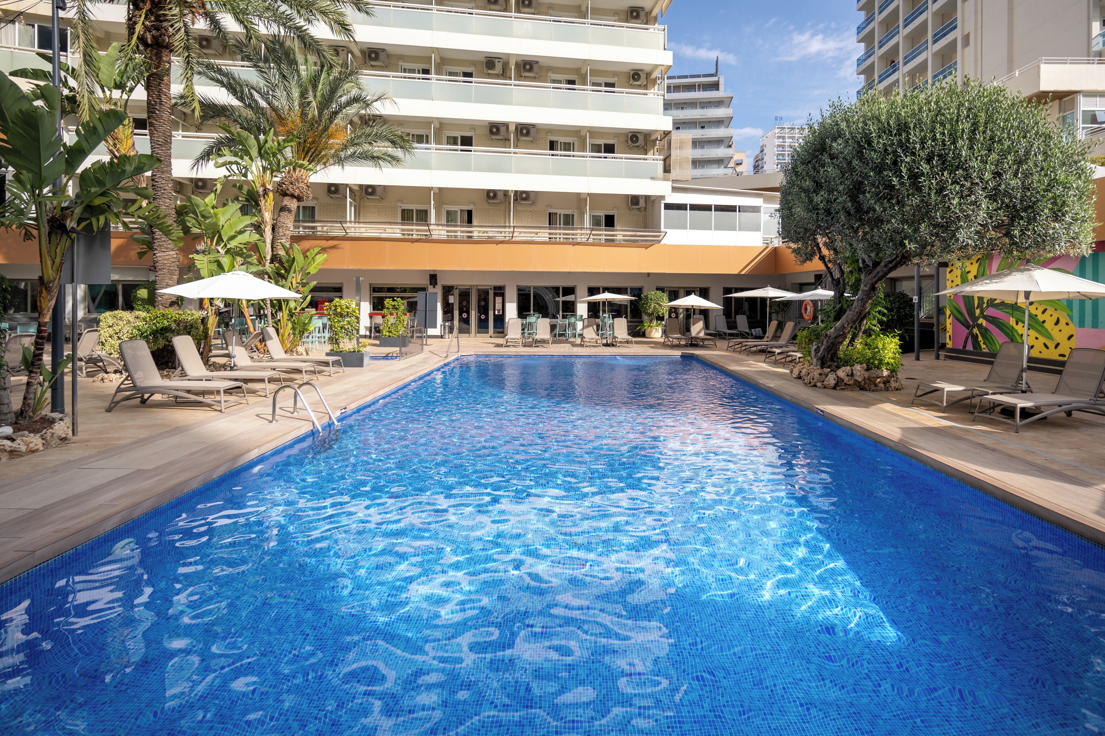 Una piscina cubierta, una piscina al aire libre, tumbonas