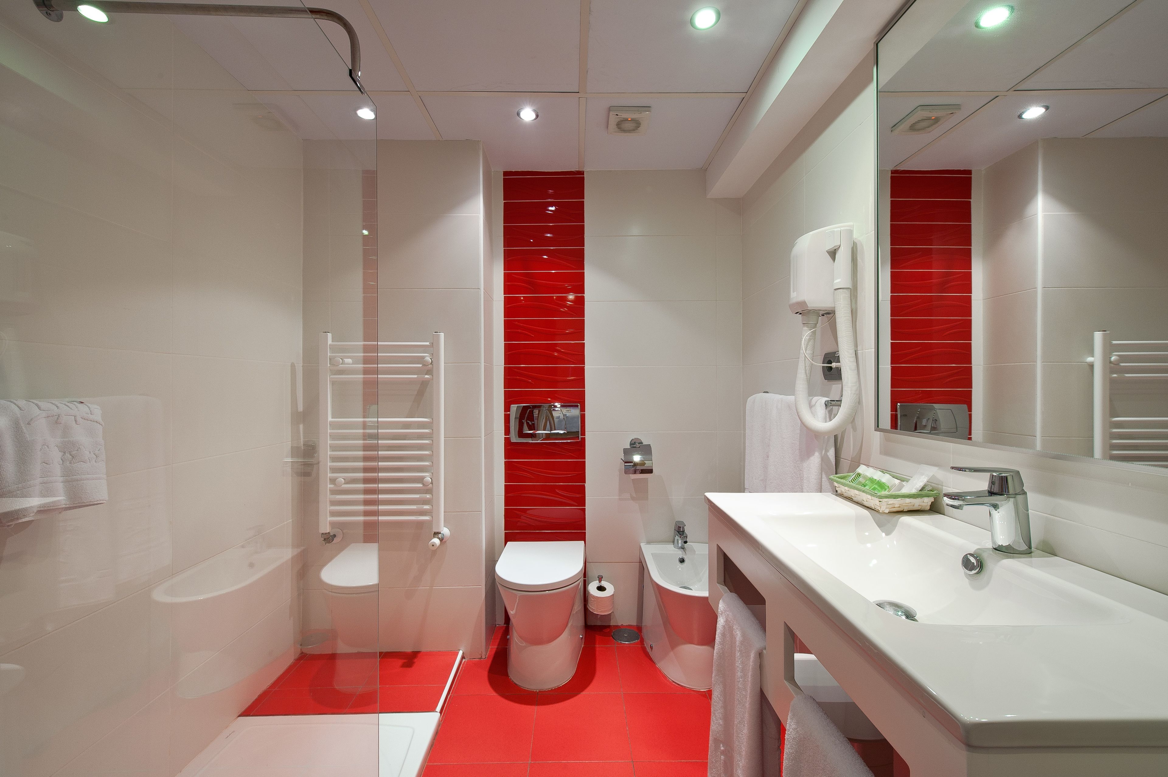 A modern bathroom with a white sink, a toilet, and a shower area.