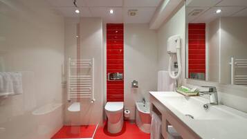 A modern bathroom with a white sink, a toilet, and a shower area.