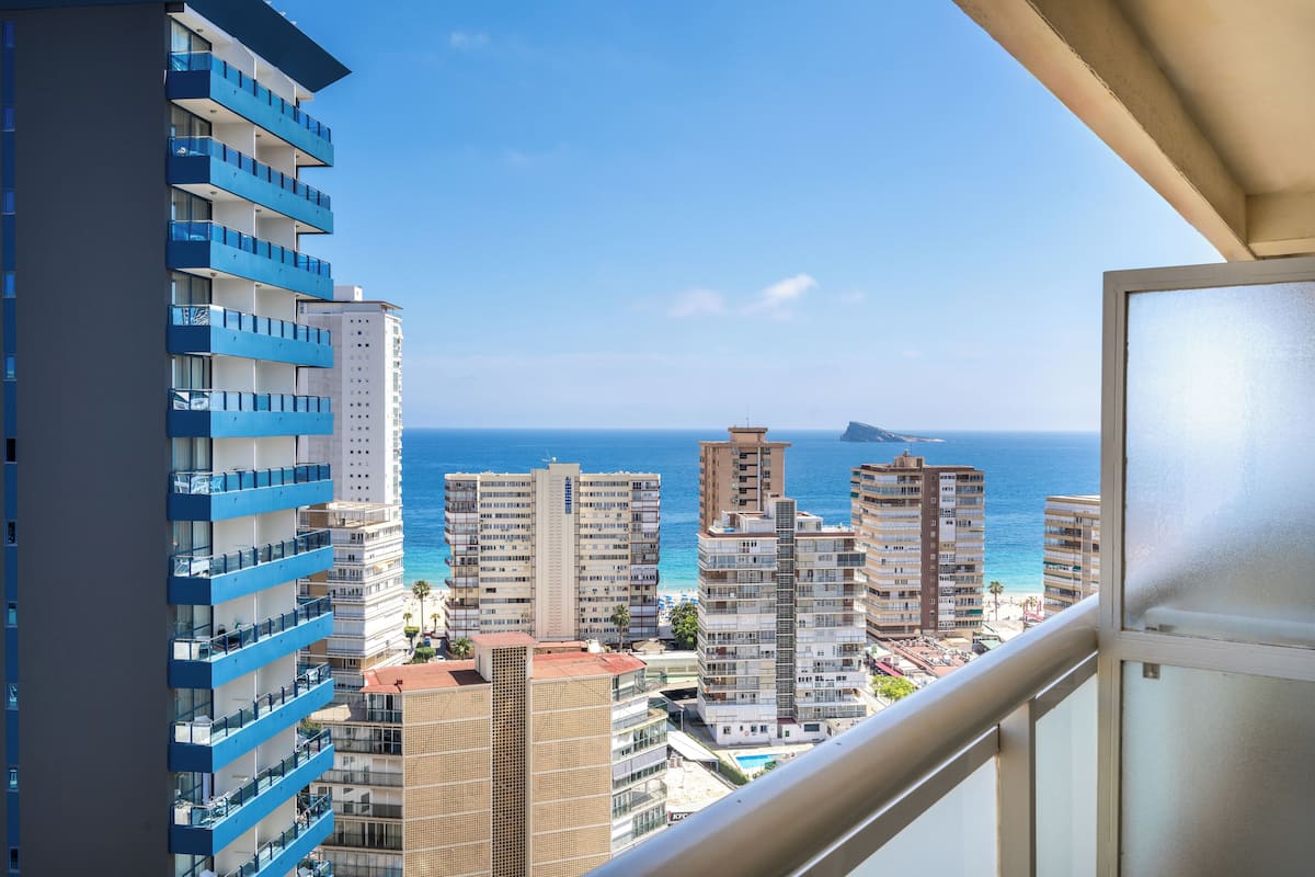 Un edificio de gran altura con varios balcones que dan a una ciudad costera.