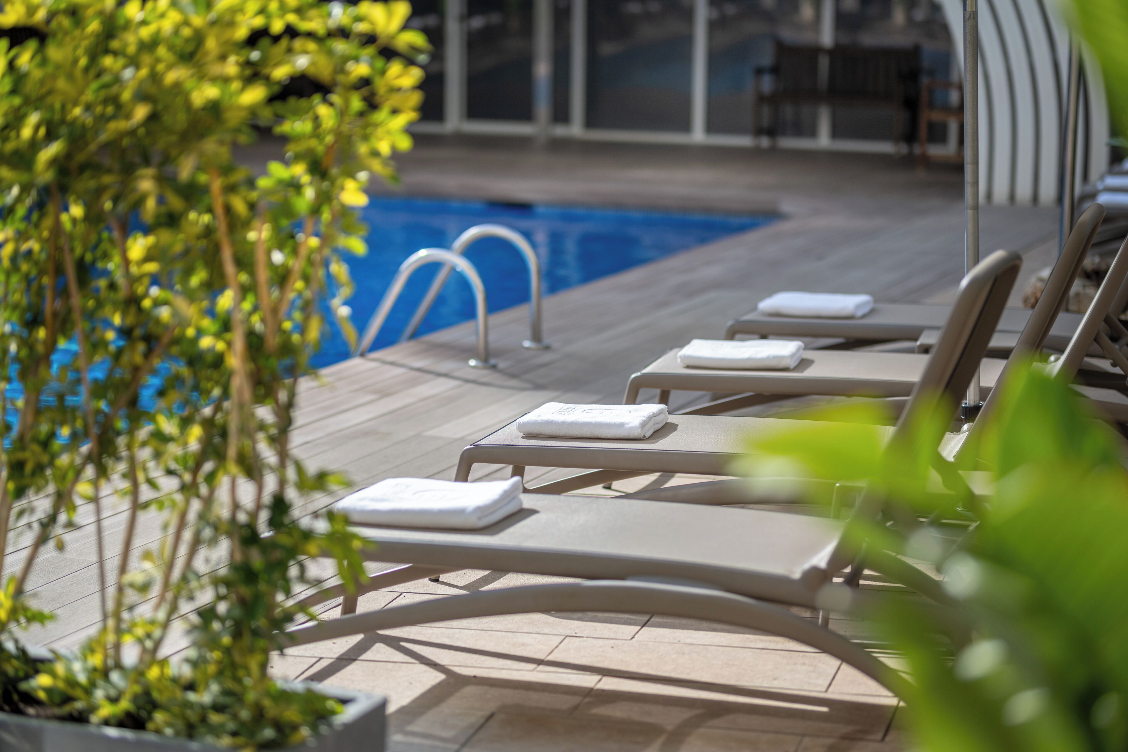 Un espace aménagé au bord de la piscine, avec des chaises longues et une petite piscine.