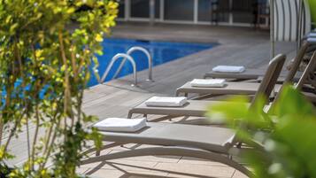 Un espace aménagé au bord de la piscine, avec des chaises longues et une petite piscine.