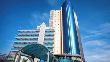 Un hotel de diseño moderno, con una destacada torre azul y una zona de acceso cubierta.