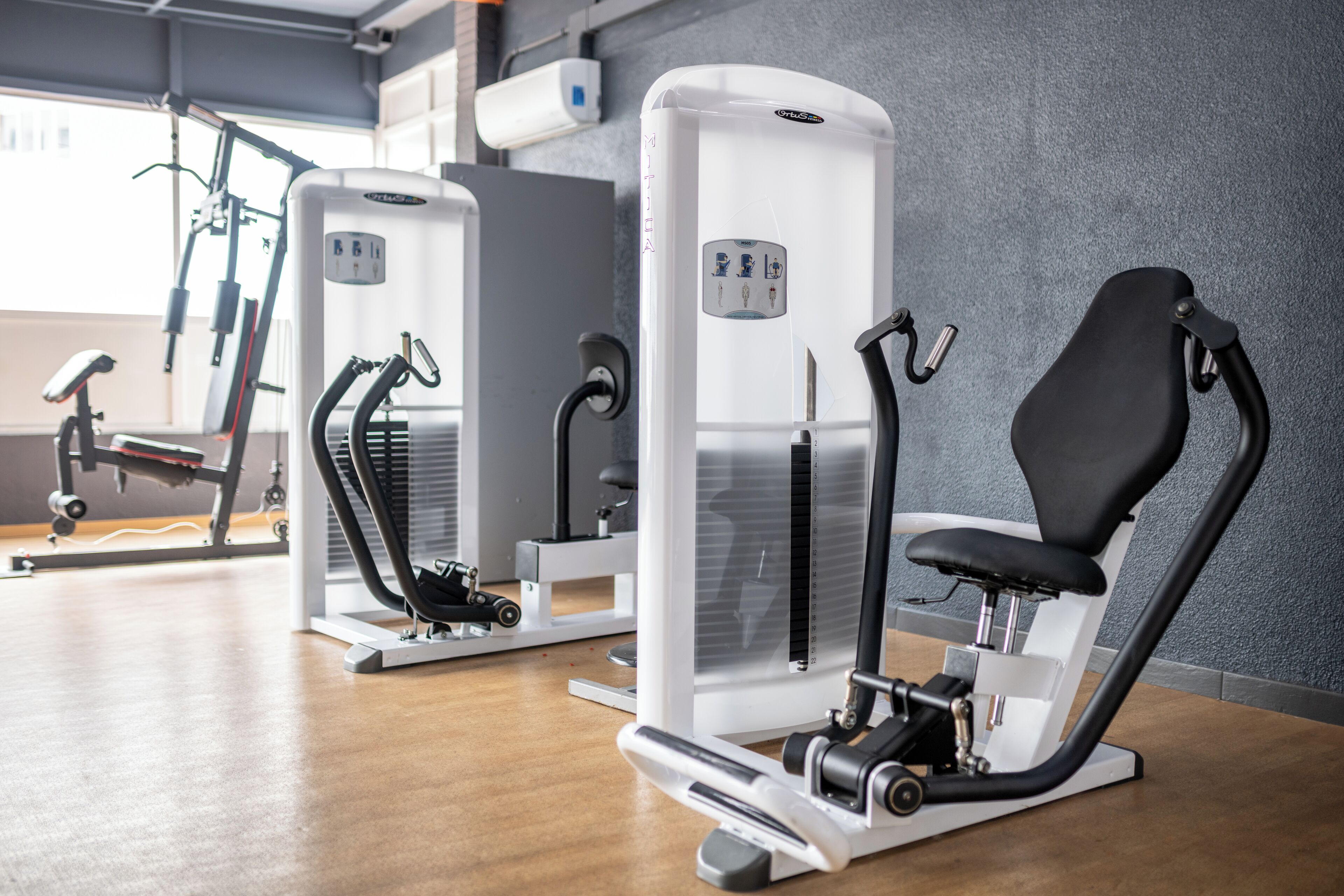 A gym with cardio machines, weight machines, and a rowing machine.