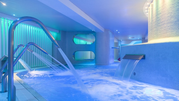 A hot tub with water jets, a metal ladder, and a tiled wall with a hexagonal pattern. - Hotel Ambassador Playa I (Benidorm)