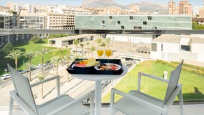 A balcony with a table set for breakfast, overlooking a cityscape with buildings and mountains. - Hotel Agua Azul - Adults Only (Benidorm)