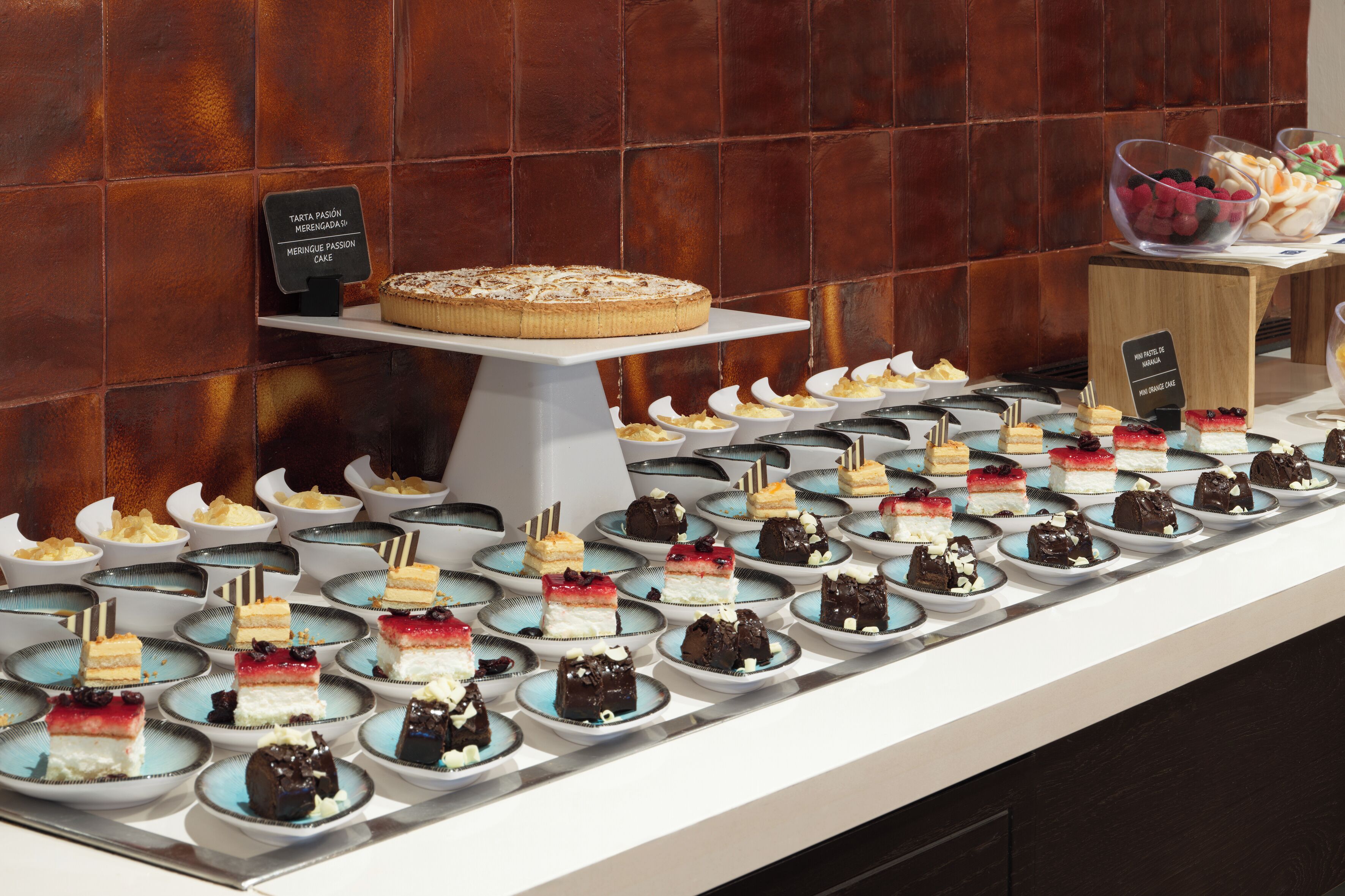 A dessert display with various cakes and pastries on a counter.