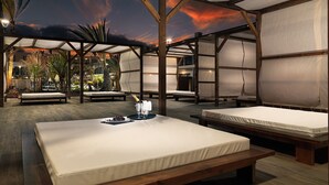 A spacious outdoor lounge area with wooden beds and a view of the sunset. - H10 Ocean Dreams Boutique Hotel - Adults Only (La Oliva)