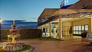 Un edificio con un espacio al aire libre techado, una fuente y vistas al océano.