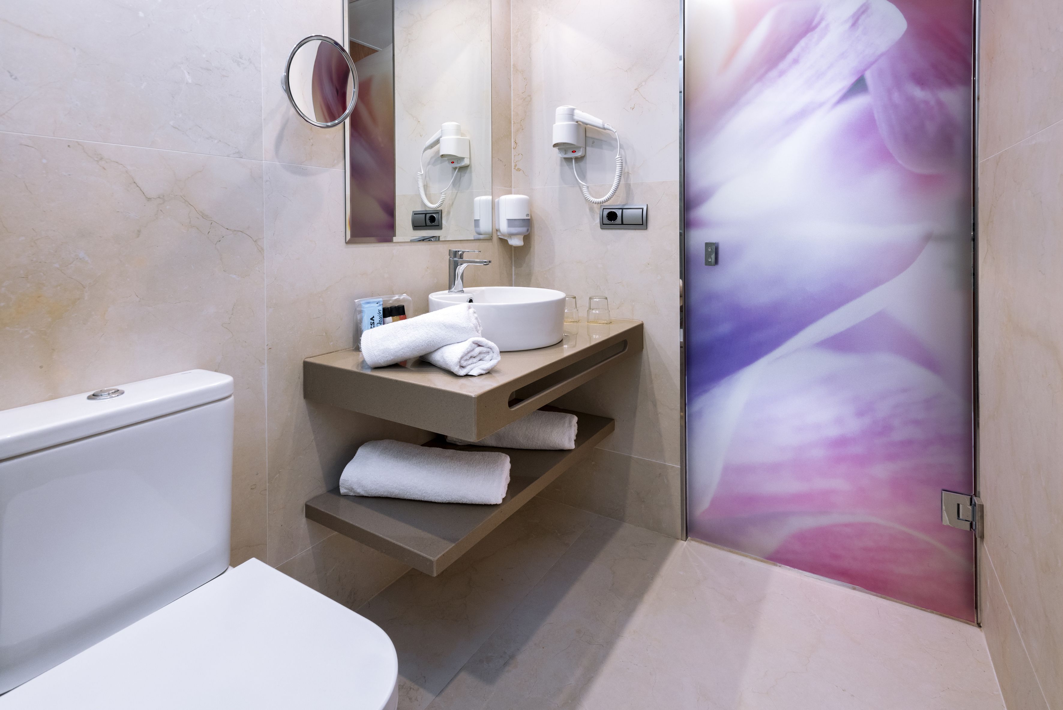 Un baño moderno con inodoro, lavabo y ducha.