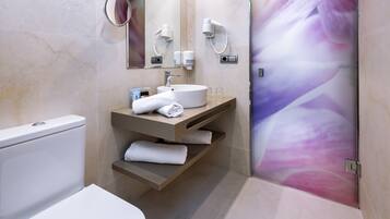 Un baño moderno con inodoro, lavabo y ducha.