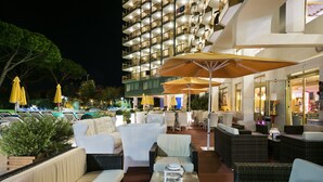 An outdoor lounge area with wicker furniture, yellow umbrellas, and a poolside view. - Beverly Park Hotel & Spa (Blanes)