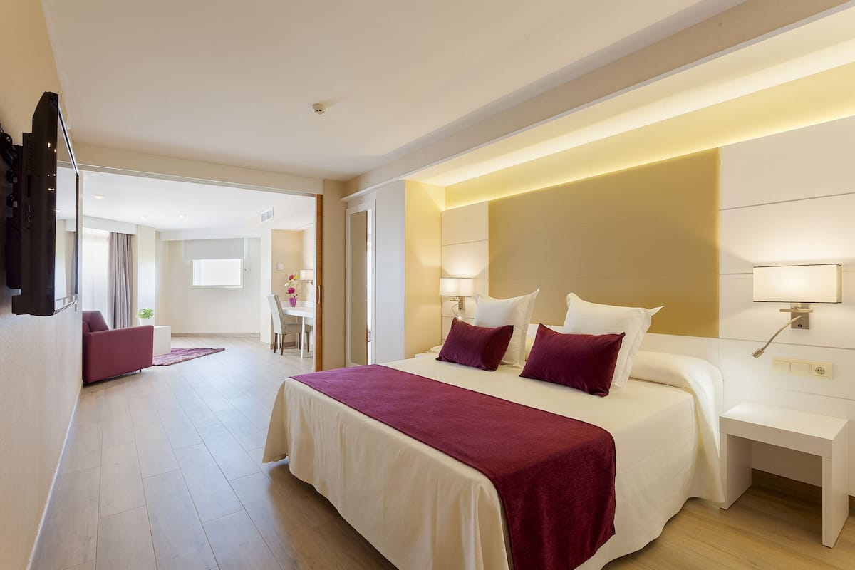 Una habitación de hotel moderna con una cama grande, mesitas de noche y un escritorio.