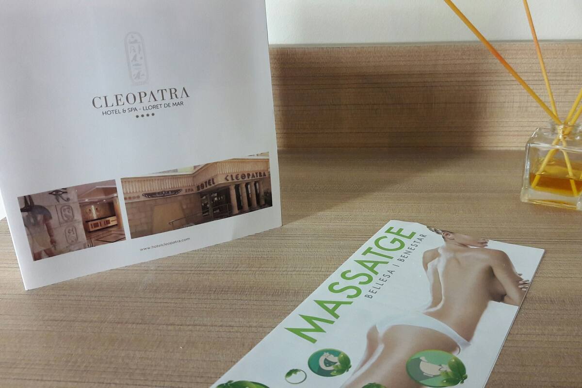 A brochure for the Cleopatra Hotel & Spa, featuring a spa advertisement and a small glass bottle with reed sticks.