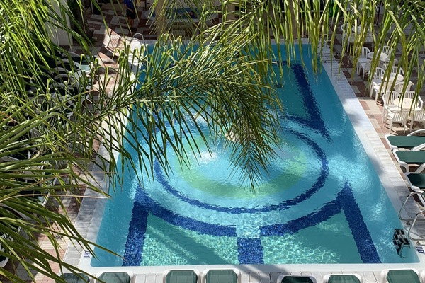 Una piscina al aire libre, sillones reclinables de piscina