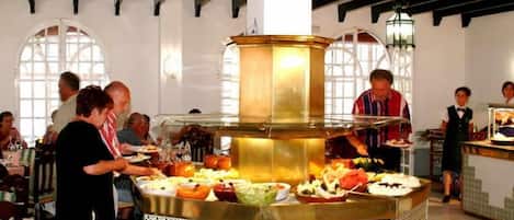 Montaje de bufé con una estación central de servicio y varios alimentos.