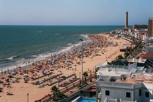 Una playa cerca, arena blanca, sillas reclinables de playa, sombrillas