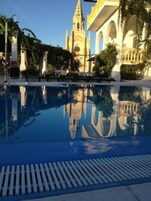 Una piscina al aire libre de temporada, sombrillas