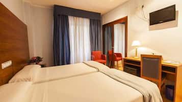 Minibar, escritorio, tabla de planchar con plancha y ropa de cama