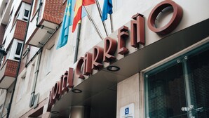 A building with the sign "HOTEL CARRETO" and multiple flags.