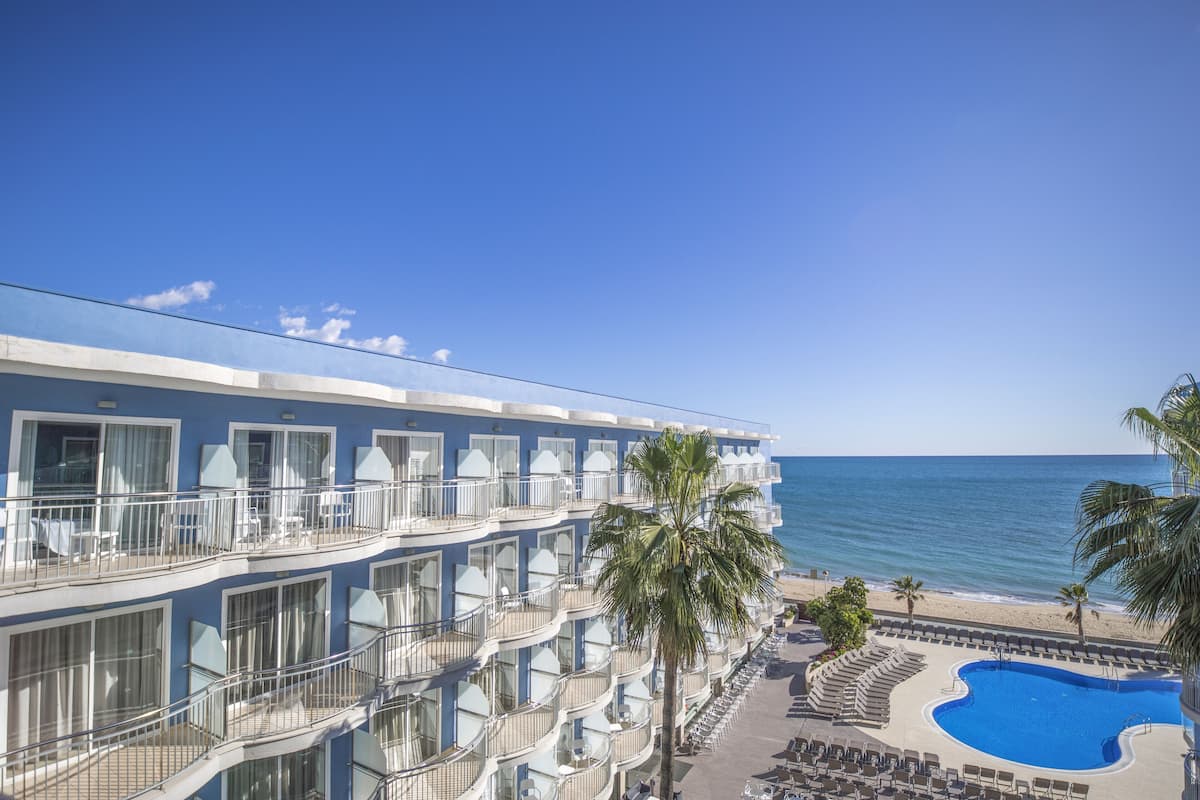 Un hôtel doté de nombreux balcons, d’une piscine et offrant une vue sur la plage.