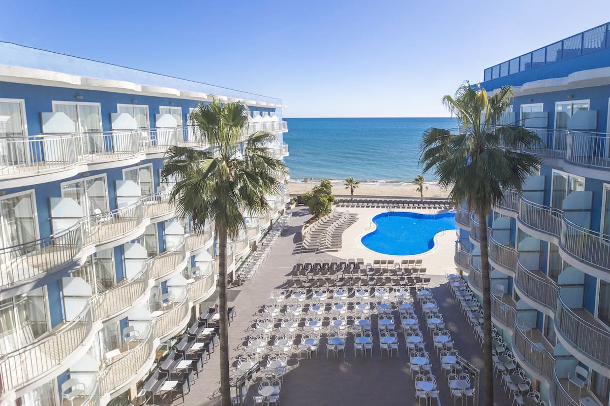 Un hôtel doté de nombreux balcons, d’une piscine et d’espaces extérieurs aménagés pour se détendre.