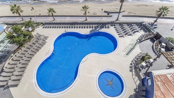 Una piscina al aire libre, tumbonas