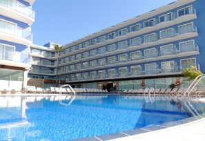 Un hotel con piscina, varios balcones y un diseño arquitectónico moderno.
