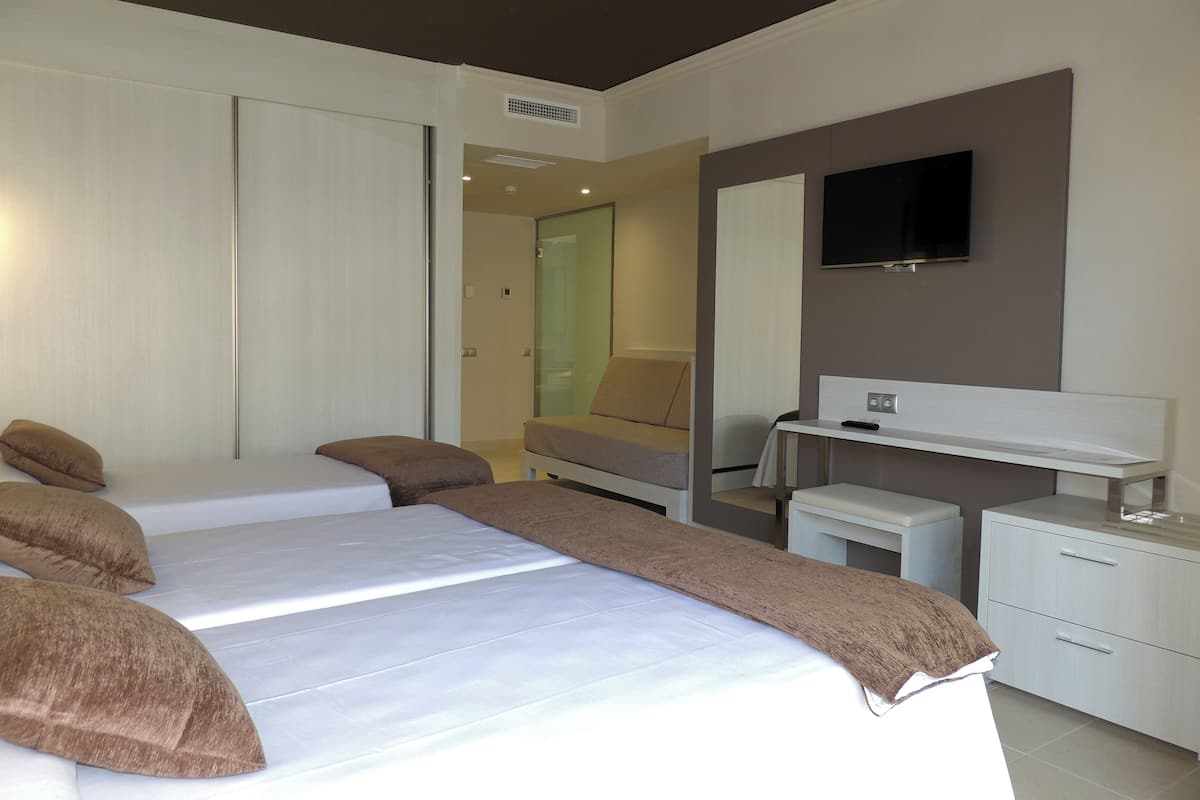 Une chambre d’hôtel moderne équipée d’un grand lit, d’un bureau, d’une chaise et d’une télévision.
