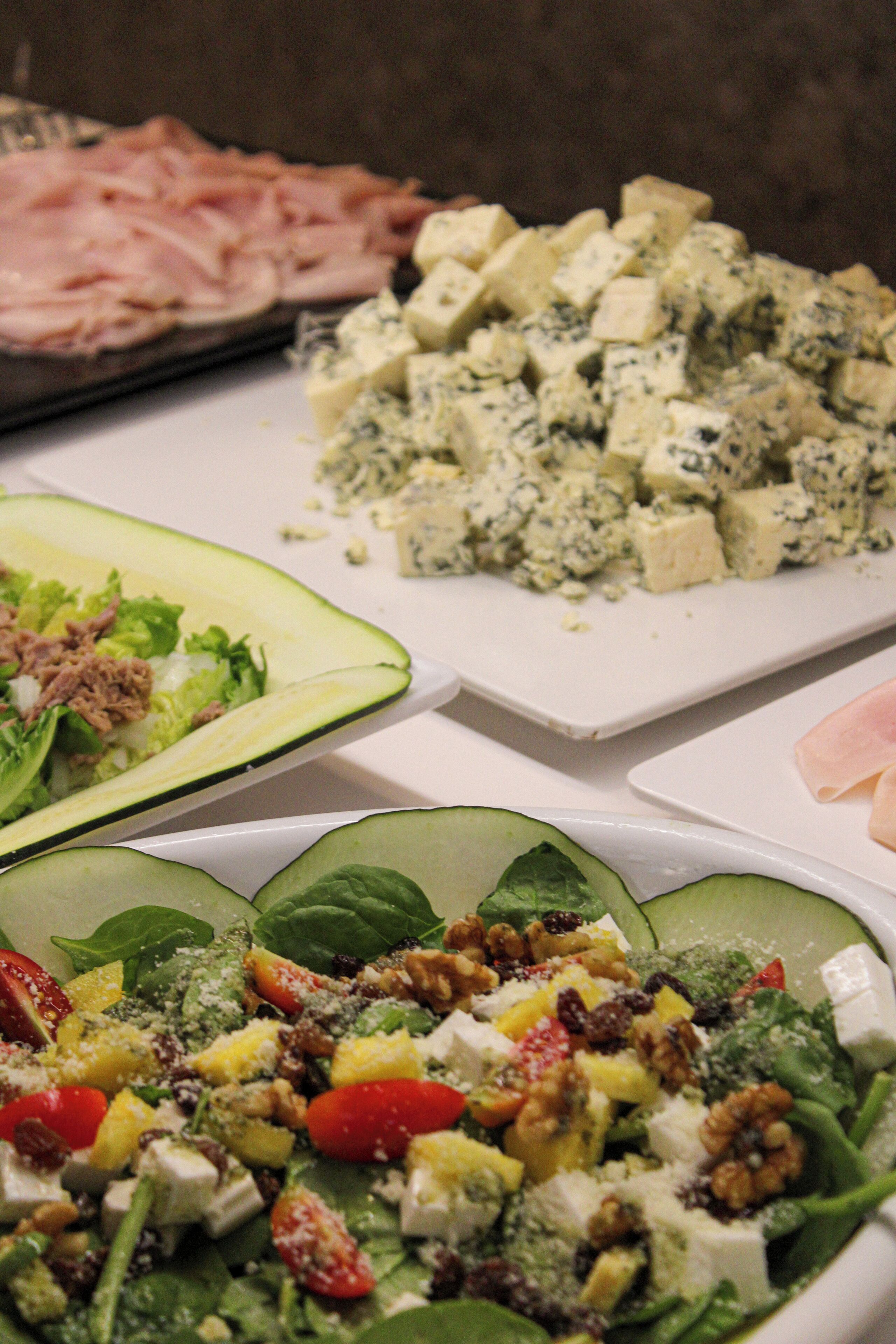 Diversos tipos de alimentos, como una ensalada, un plato con cubos y carne en porciones.
