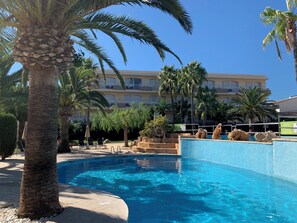 Una piscina al aire libre de temporada, sillones reclinables de piscina