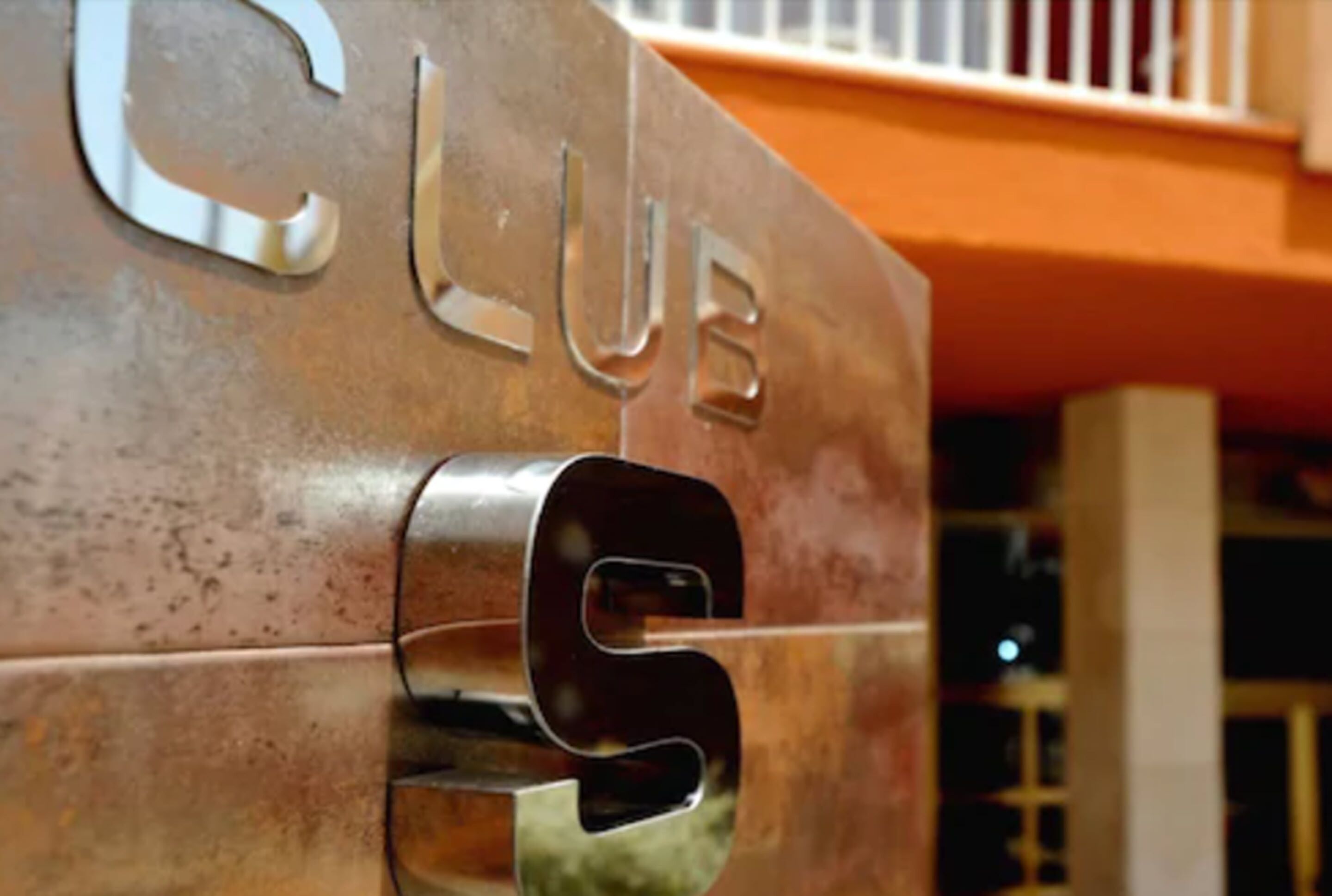 A metallic sign with the word "CLUB" and a keyhole design.