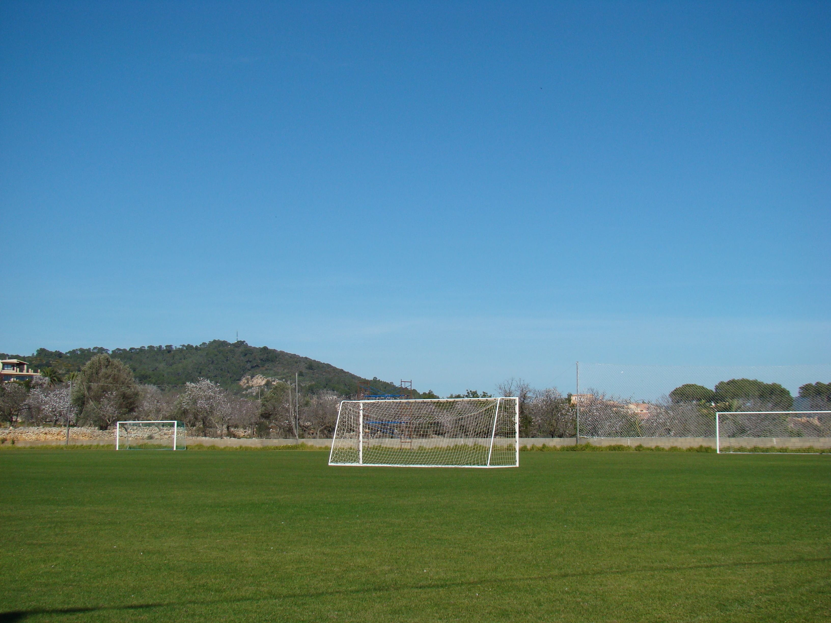 Een voetbalveld met doelen en een heldere lucht.
