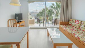 Une chambre d’hôtel moderne dotée d’un balcon, d’un canapé, d’une table à manger et d’un téléviseur.