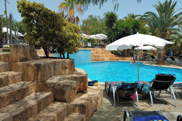 Una piscina al aire libre de temporada, sillones reclinables de piscina