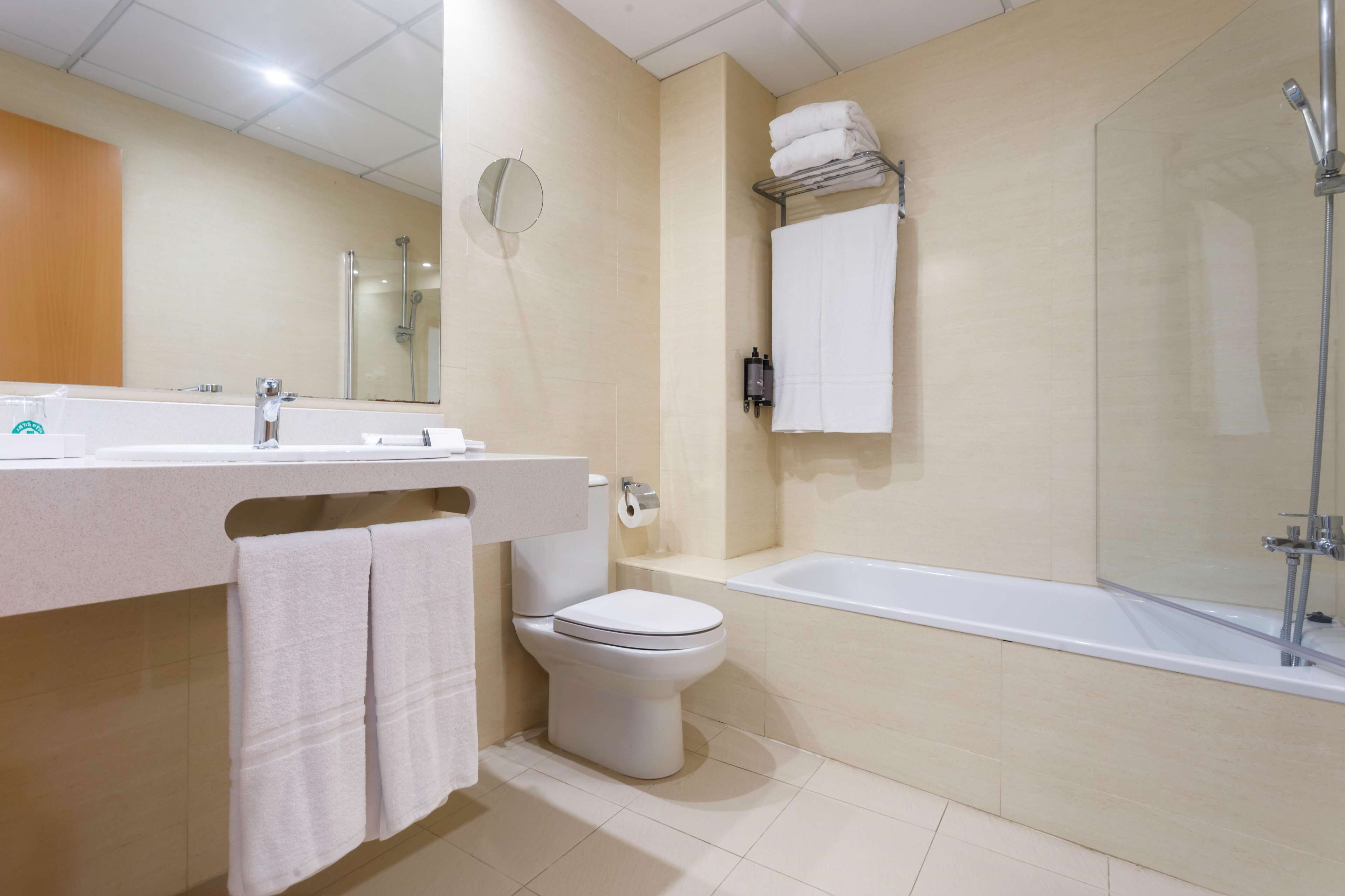 Un baño moderno con inodoro, lavamanos y bañera.