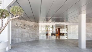 A modern lobby with a marble floor, a large tree, and a sign that reads "Best Cameras". - Hotel Best Cambrils (Cambrils)