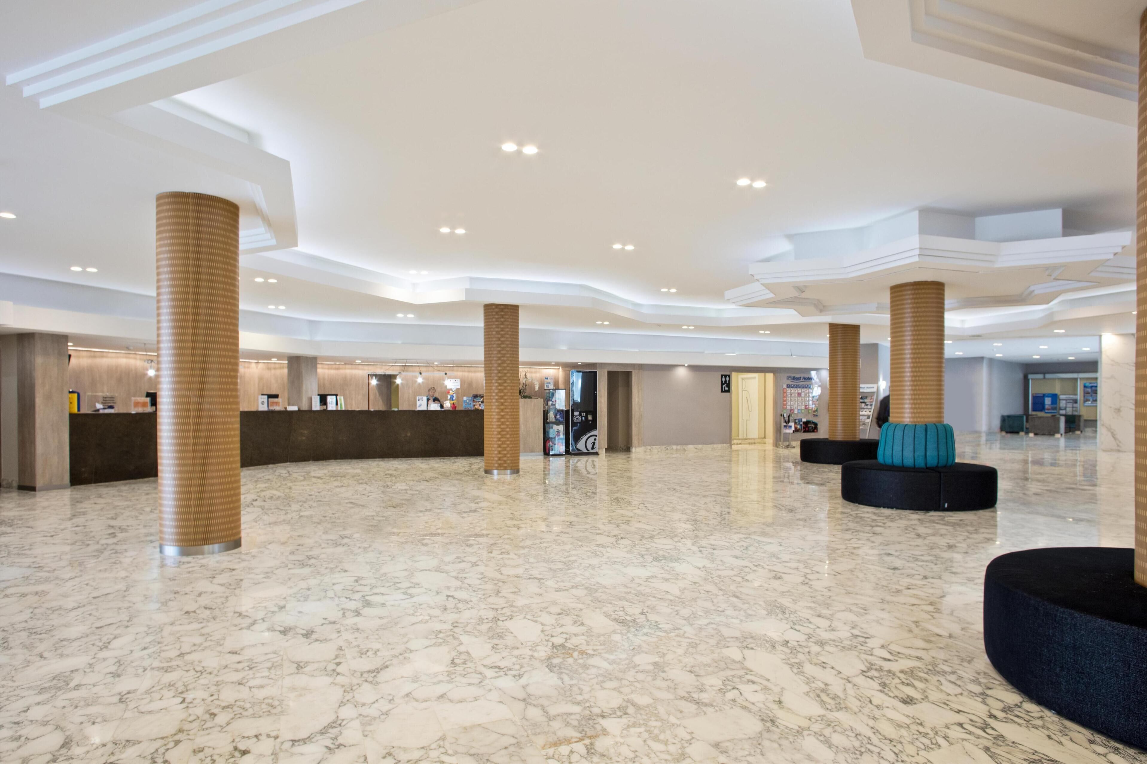 Eine großzügige Lobby mit Marmorböden, mehreren Rezeptionstheken und modernen architektonischen Elementen.