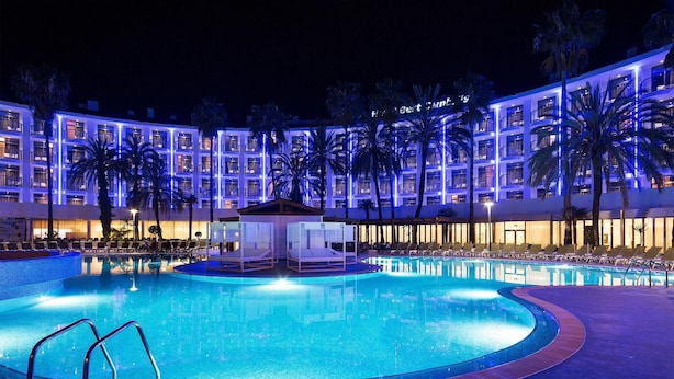 A hotel pool area with a large pool, lounge chairs, and palm trees. - Hotel Best Cambrils (Cambrils)