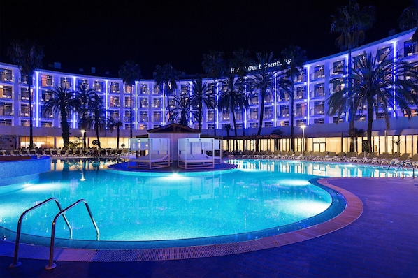 Een buitenzwembad, parasols bij het zwembad en ligstoelen