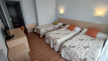Una habitación de hotel con dos camas, un escritorio, una silla y una puerta.