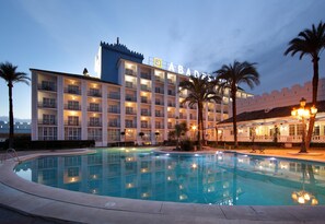 A hotel with a swimming pool, multiple balconies, and a well-lit facade. - Hotel Abades Benacazón (Benacazon)