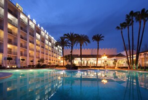 Una piscina al aire libre de temporada, sombrillas